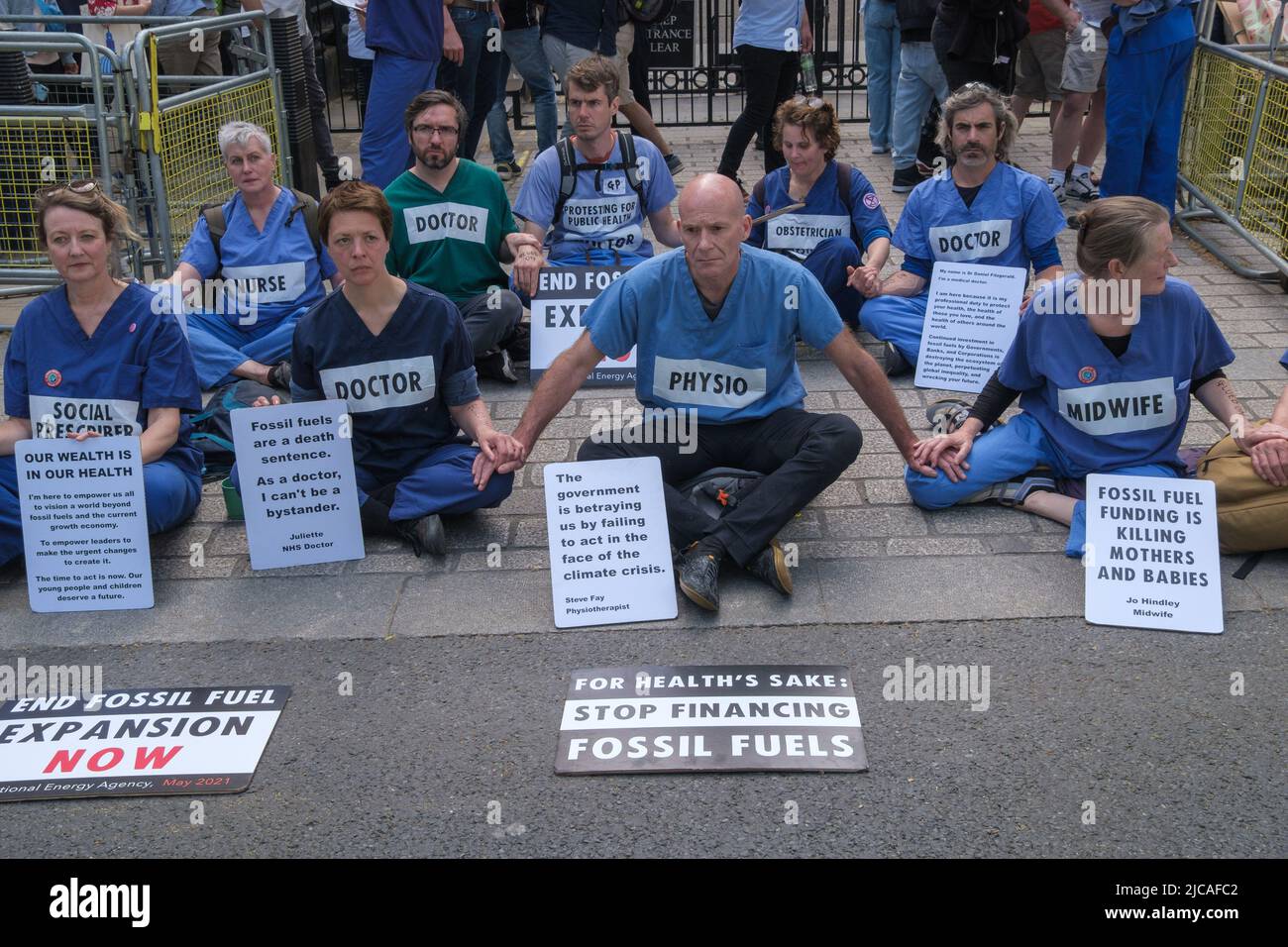 Londra, Regno Unito. 11 giugno 2022. Medici, ostetriche, infermieri e altro personale medico in Medici per la ribellione estinzione bloccare l'ingresso a Downing St in una protesta sit-down contro il governo che approva il nuovo combustibile fossile per il Regno Unito. Le mani incollate e sedettero di fronte all'entrata, dicendo che il governo ci sta tradendo non agendo di fronte alla crisi climatica e che il combustibile fossile sta uccidendo madri e bambini. Peter Marshall / Alamy Live News Foto Stock