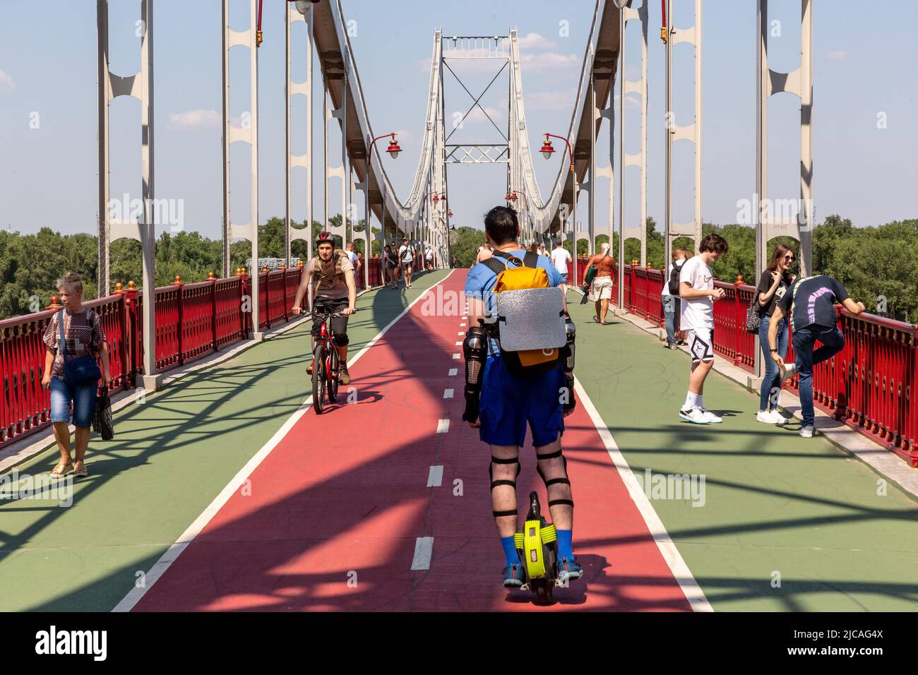 Kiev, Ucraina. 11th giugno 2022. Gli ucraini sono visti attraversare un ponte pedonale sul fiume Dnipro in una calda giornata di sole in una città vecchia di Kyiv, Ucraina il 11 giugno 2022. Mentre la Federazione russa ha invaso l'Ucraina 3 mesi e mezzo fa, continuano feroci combattimenti nell'est del paese. La capitale, Kiev rimane in relativa sicurezza e la popolazione rivendica lo spazio pubblico e apre la strada alla normalizzazione. (Foto di Dominika Zarzycka/Sipa USA) Credit: Sipa USA/Alamy Live News Foto Stock