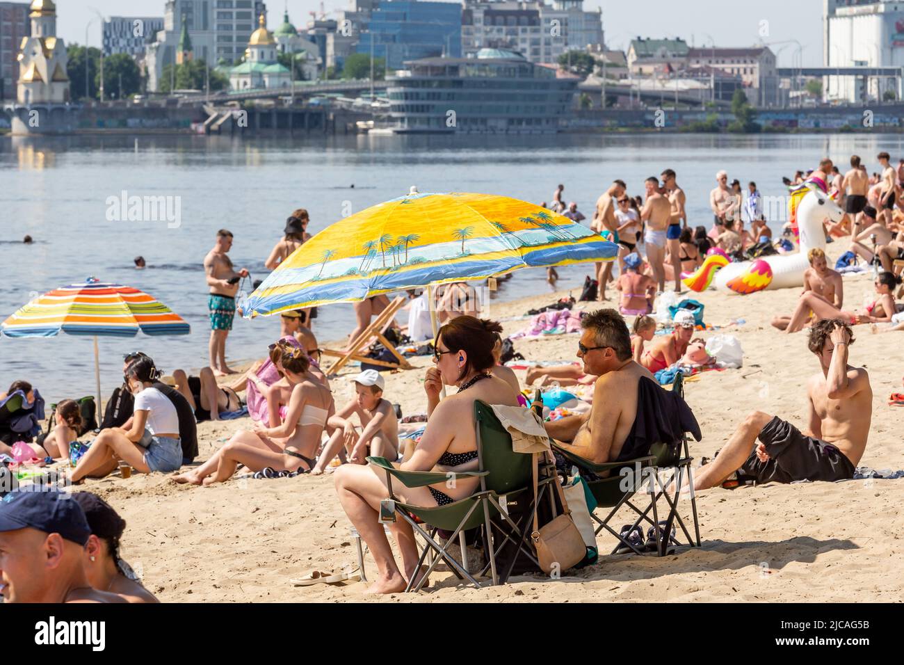 Kiev, Ucraina. 11th giugno 2022. Gli ucraini sono visti fare il bagno nel fiume Dnipro alla spiaggia pubblica in una giornata calda di sole in una città vecchia di Kyiv, Ucraina il 11 giugno 2022. Mentre la Federazione russa ha invaso l'Ucraina 3 mesi e mezzo fa, continuano feroci combattimenti nell'est del paese. La capitale, Kiev rimane in relativa sicurezza e la popolazione rivendica lo spazio pubblico e apre la strada alla normalizzazione. (Foto di Dominika Zarzycka/Sipa USA) Credit: Sipa USA/Alamy Live News Foto Stock