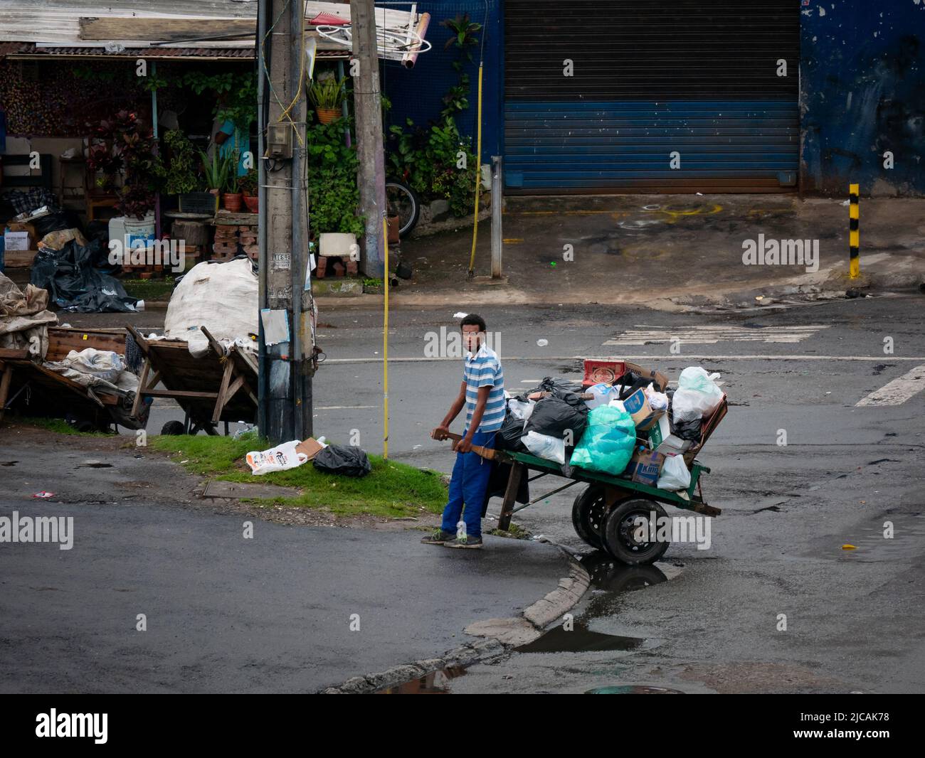 Medellin, Antioquia, Colombia - Marzo 6 2022: Uomo marrone con un Wheelbarrow per il riciclaggio e la raccolta di rifiuti Foto Stock