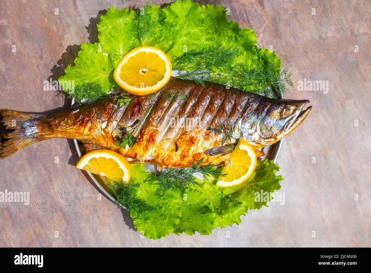 Pesce rosso alla griglia salmone rosa con limone ed erbe. Cucinare cibo delizioso e sano. Foto Stock