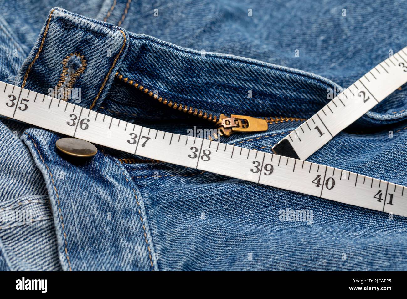 Pantaloni e nastro di misurazione della vita. Dieta, perdita di peso e concetto di guadagno. Foto Stock