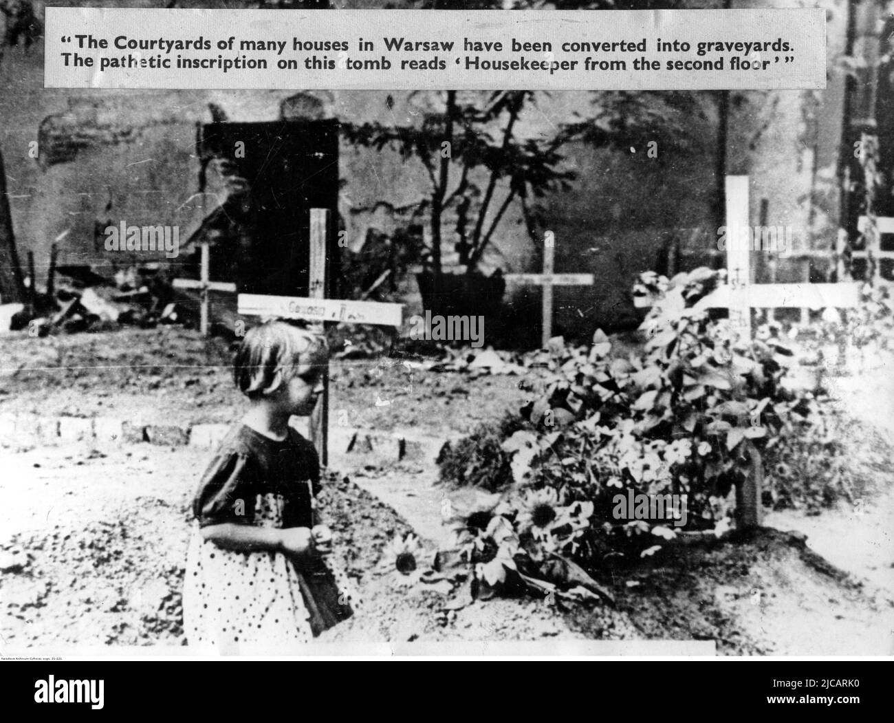 Una bambina che passa accanto alle tombe dei morti che sono state sepolte nei giardini durante l'insurrezione di Varsavia. L'insurrezione di Varsavia fu un tentativo massiccio da parte dell'esercito domestico polacco di sconfiggere la Wehrmacht e l'occupazione SS verso la fine del WW2. Foto Stock