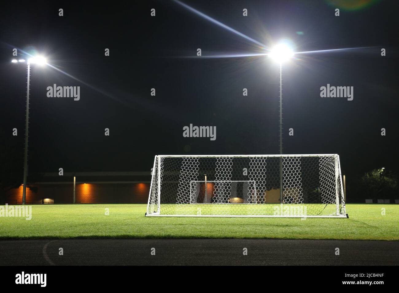 Campo da calcio vuoto di notte, illuminato da proiettori. Foto Stock