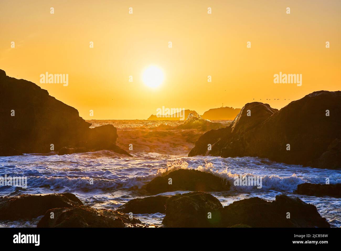 Vista al tramonto della spiaggia sulla costa coperta di massi Foto Stock