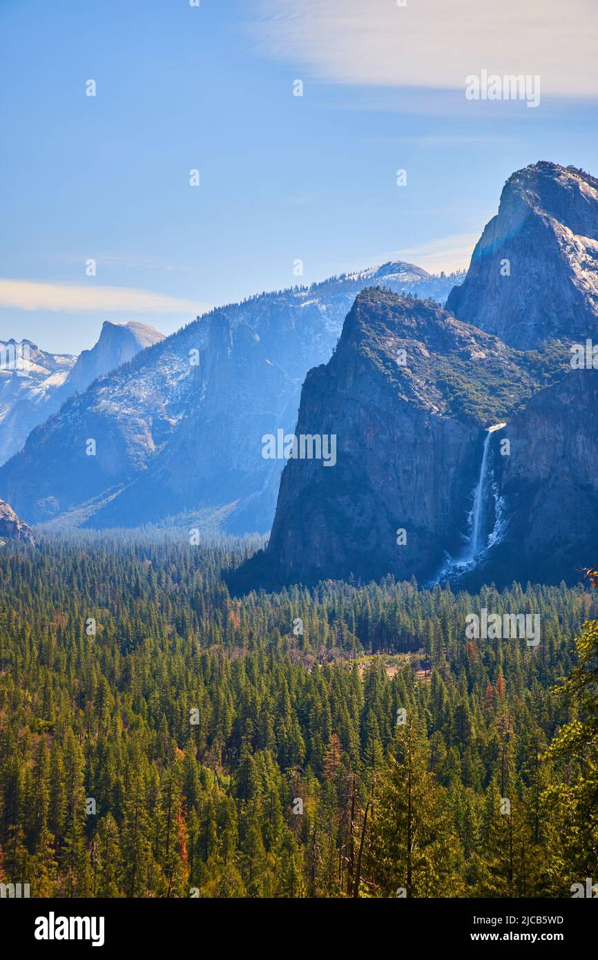 Soffusa luce mattutina sulla Yosemite Valley alle cascate Bridalveil Falls con Half Dome in lontananza Foto Stock