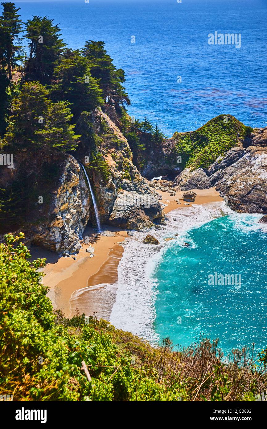 Baia sull'oceano con spiaggia sabbiosa e le iconiche cascate McWay Foto Stock