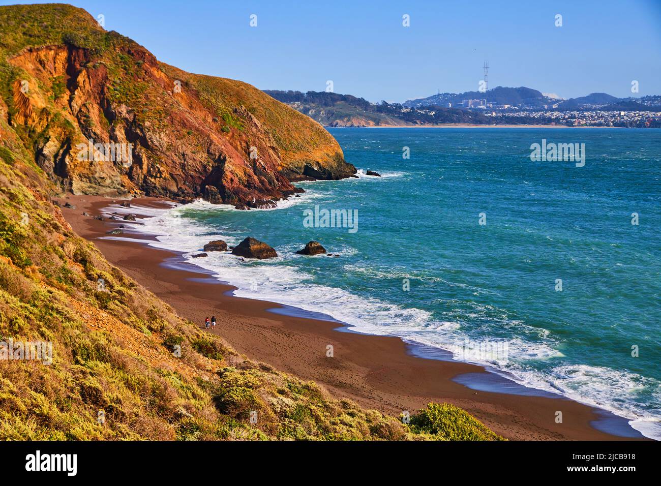 Le onde dell'oceano si infrangono sulle spiagge sabbiose della costa occidentale vicino alle colline Foto Stock