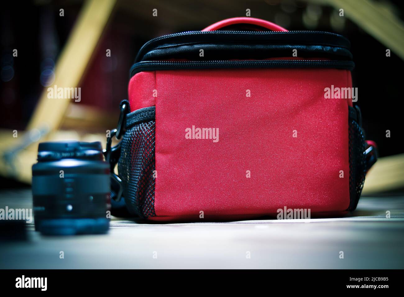 Una foto di una borsa rossa accanto ad essa ha l'obiettivo della fotocamera Foto Stock