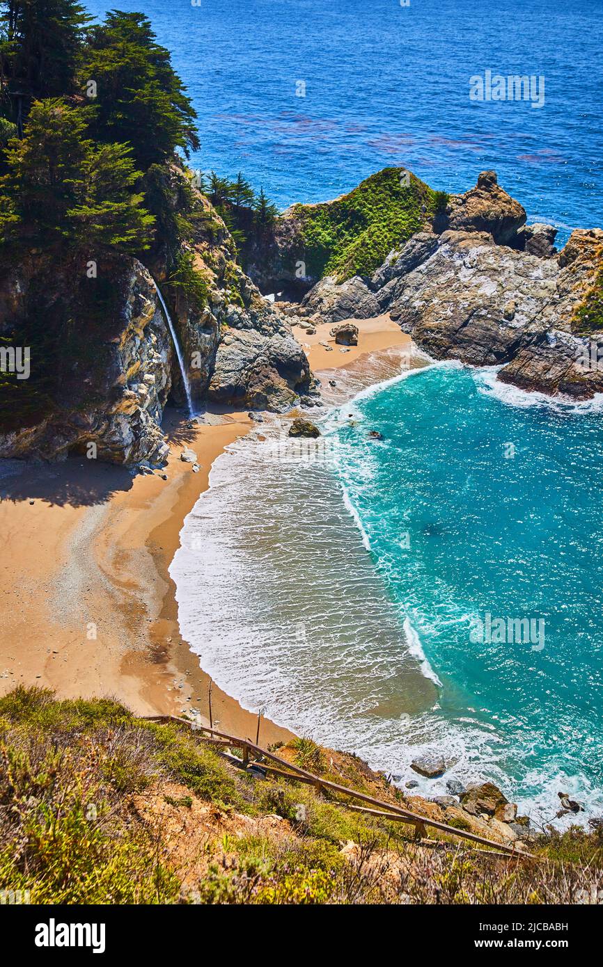 Spiaggia di sabbia con cascata nell'acqua dell'oceano Foto Stock