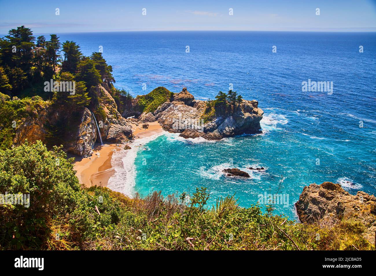 Cascata McWay nascosta nella baia costiera con spiagge sabbiose e colorate acque oceaniche Foto Stock