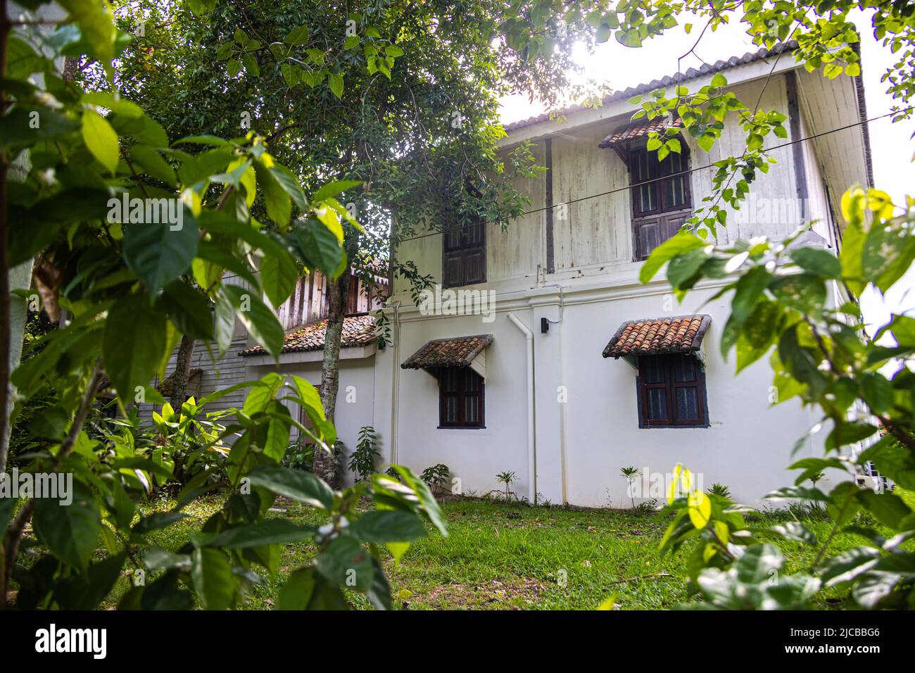 Langkawi, Malesia - 7 giugno 2022: Tradizionale casa di legno malese tra vegetazione tropicale. Tipica casa malese su palafitte. L'architettura in legno si raffredda Foto Stock