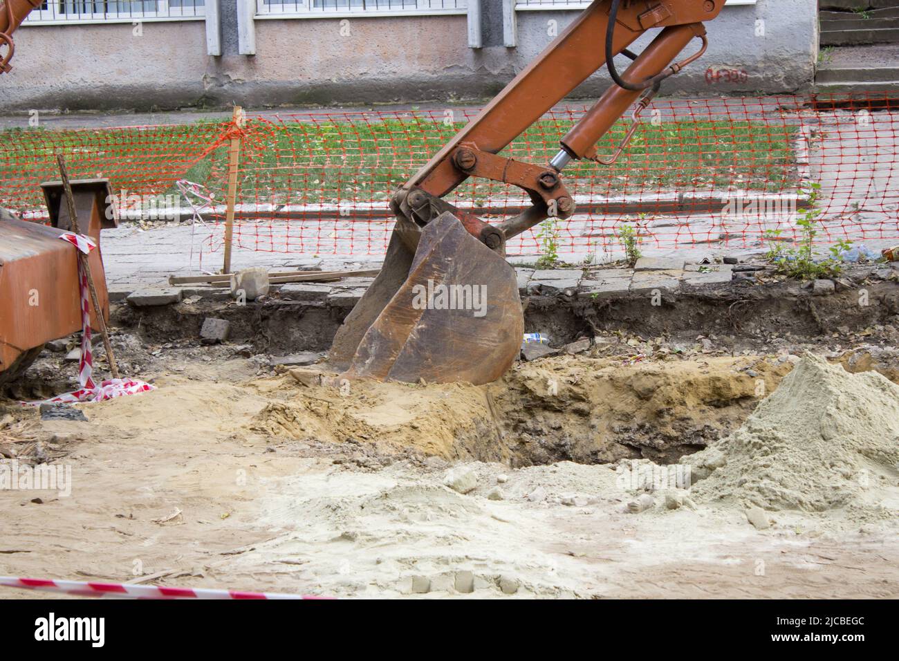 retroescavatore che ha scavato un buco riparare strade in strada Foto Stock