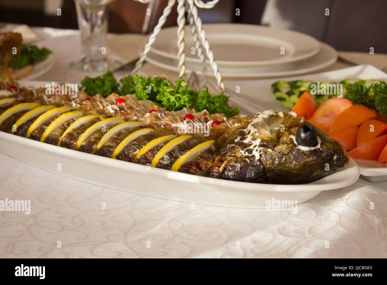 Pesce ripieno con insalata al tavolo un ristorante Foto Stock