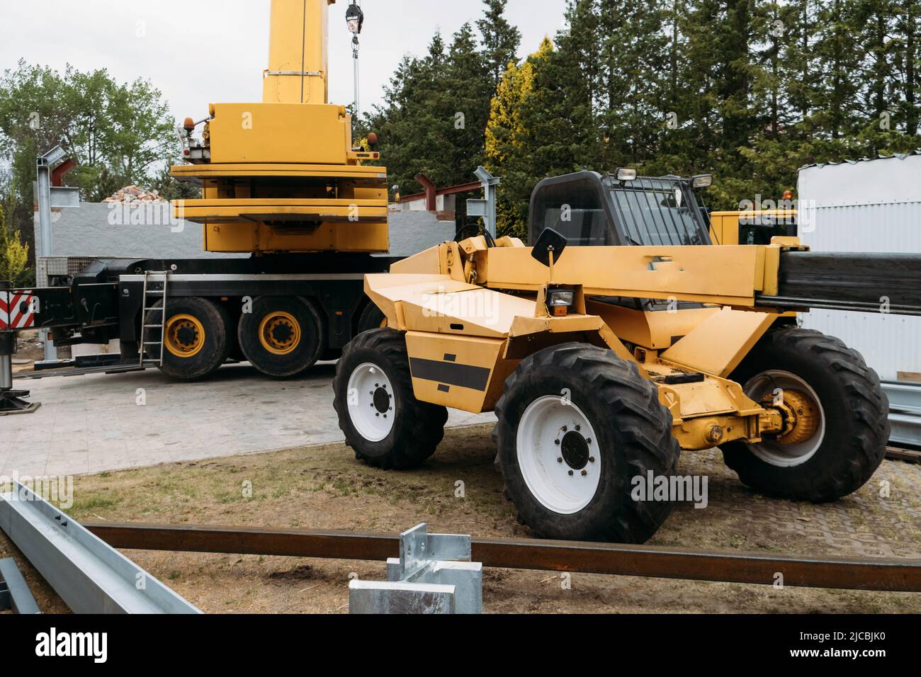 Gru da cantiere per il sollevamento di carichi pesanti. Le moderne tecnologie di trasporto mobile aiutano a costruire la casa. Azienda immobiliare professionale che lavora con Foto Stock