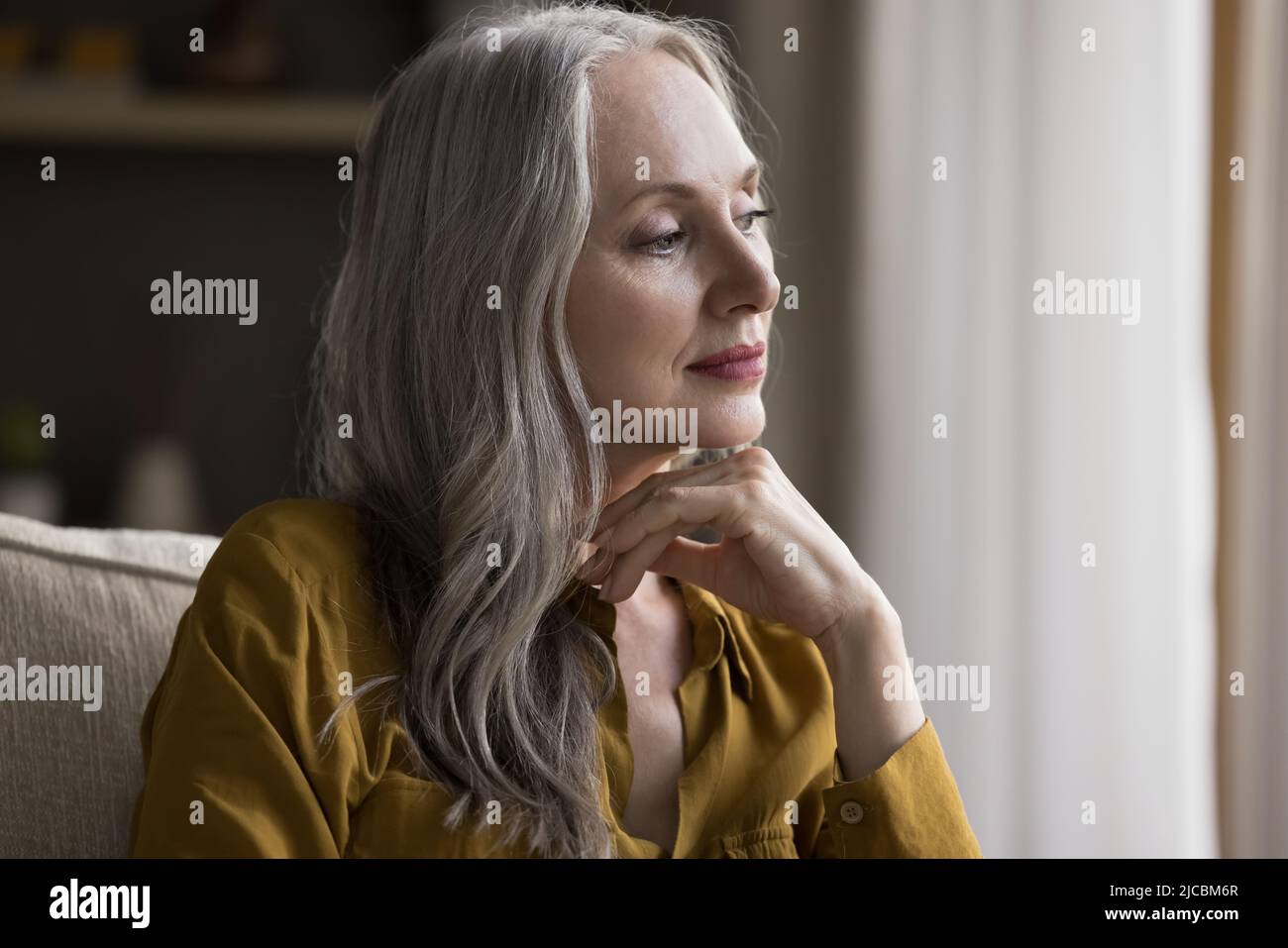 La donna più anziana sembra profonda in ricordi e pensieri piacevoli Foto Stock