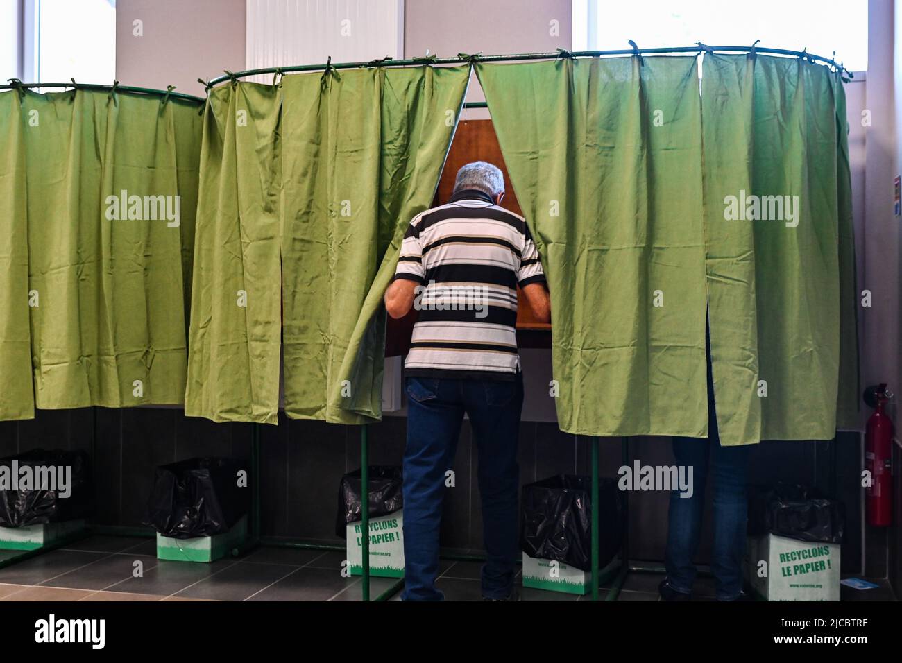 12 giugno 2022, Cours la Ville, Auvergne Rhone Alpes, Francia: Un uomo entra in una cabina di voto. Il popolo francese è chiamato a votare per il primo turno delle elezioni legislative che eleggeranno i deputati che siederanno all'Assemblea nazionale. Qui, in un seggio di Cours-la-Ville la Domenica mattina. (Credit Image: © Adrien Fillon/ZUMA Press Wire) Foto Stock