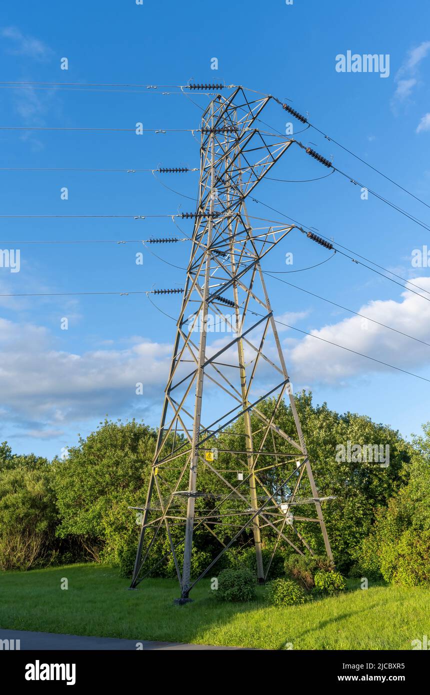 Grande pilone di alimentazione elettrica fotografato contro un cielo blu Foto Stock