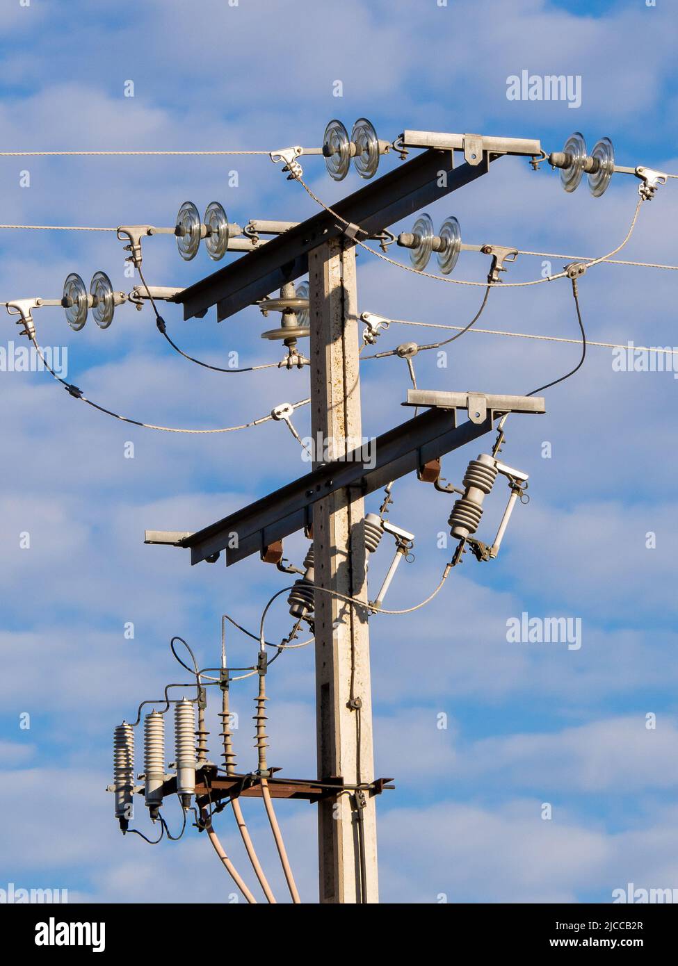 Linee elettriche ad alta tensione in un cielo blu e nuvole. Foto Stock