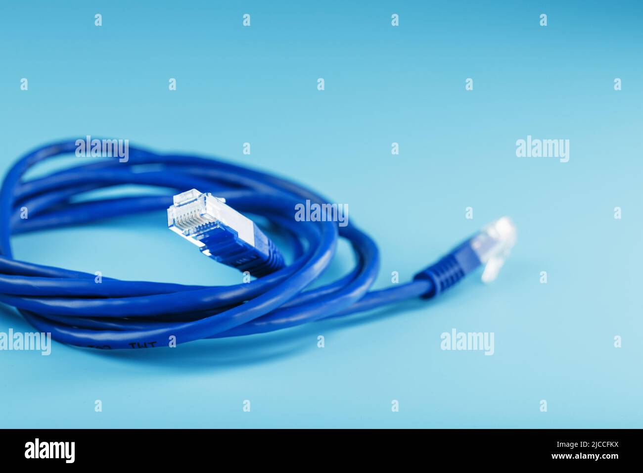 Connettori cavo Ethernet blu cavo patch close-up isolato su sfondo blu con spazio libero Foto Stock