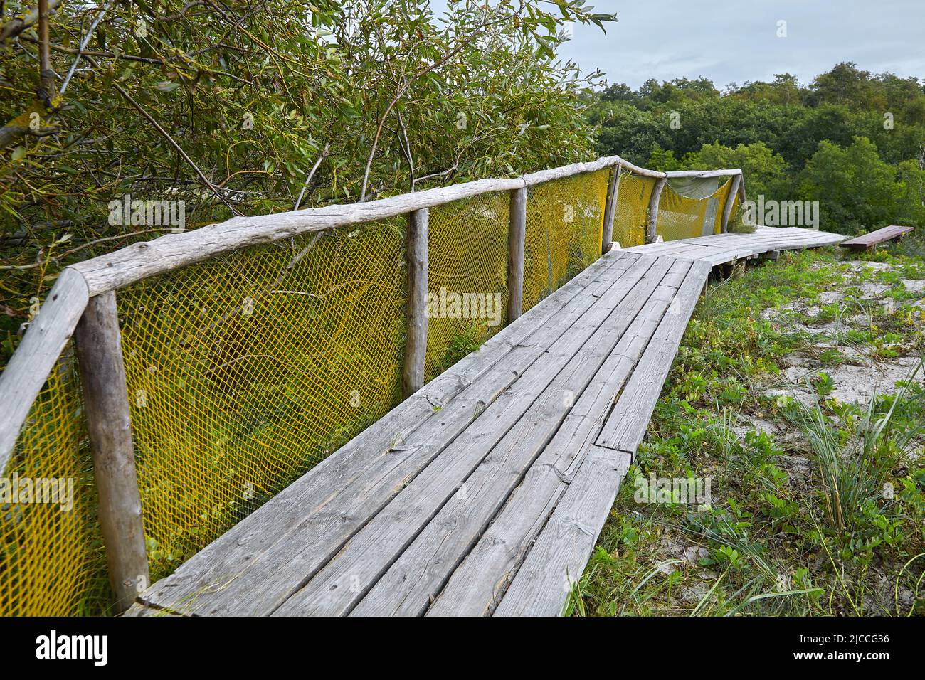 Pavimento in legno per camminare nelle dune con rete di recinzione. Riposatevi sul Mar Baltico. Turismo locale Foto Stock