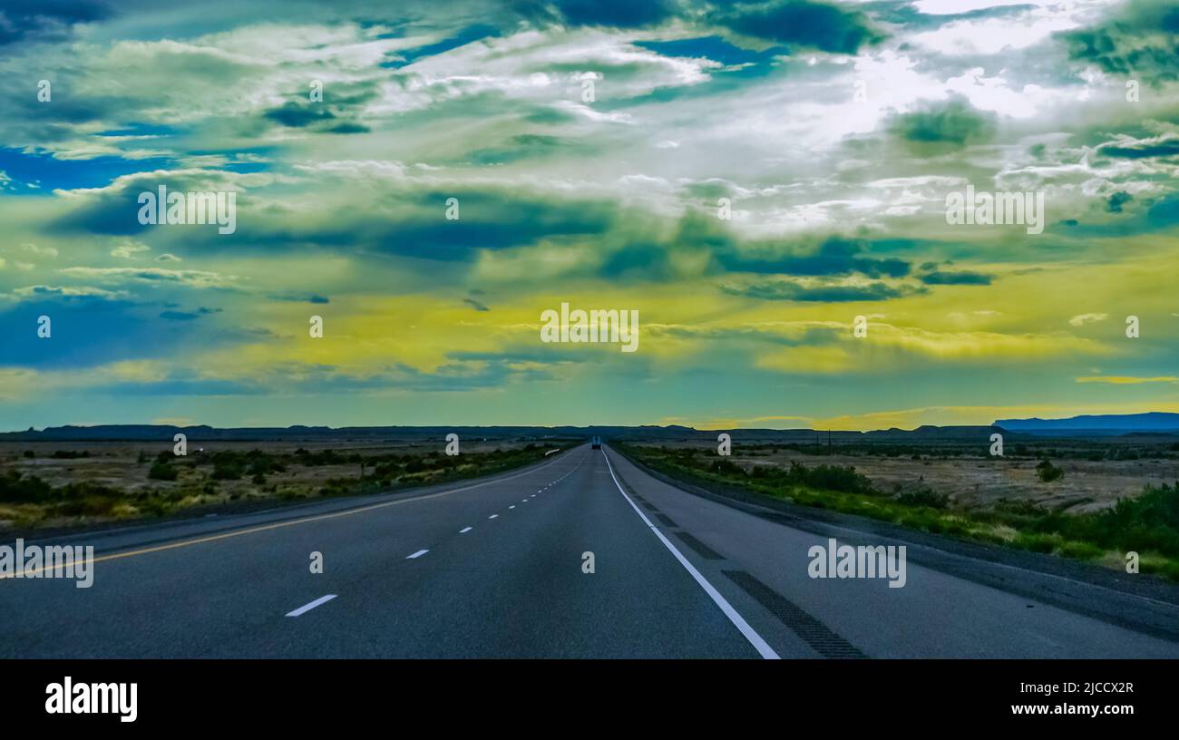 Strada asfaltata dritta e piana che si estende fino alla distanza oltre l'orizzonte in Utah, USA Foto Stock