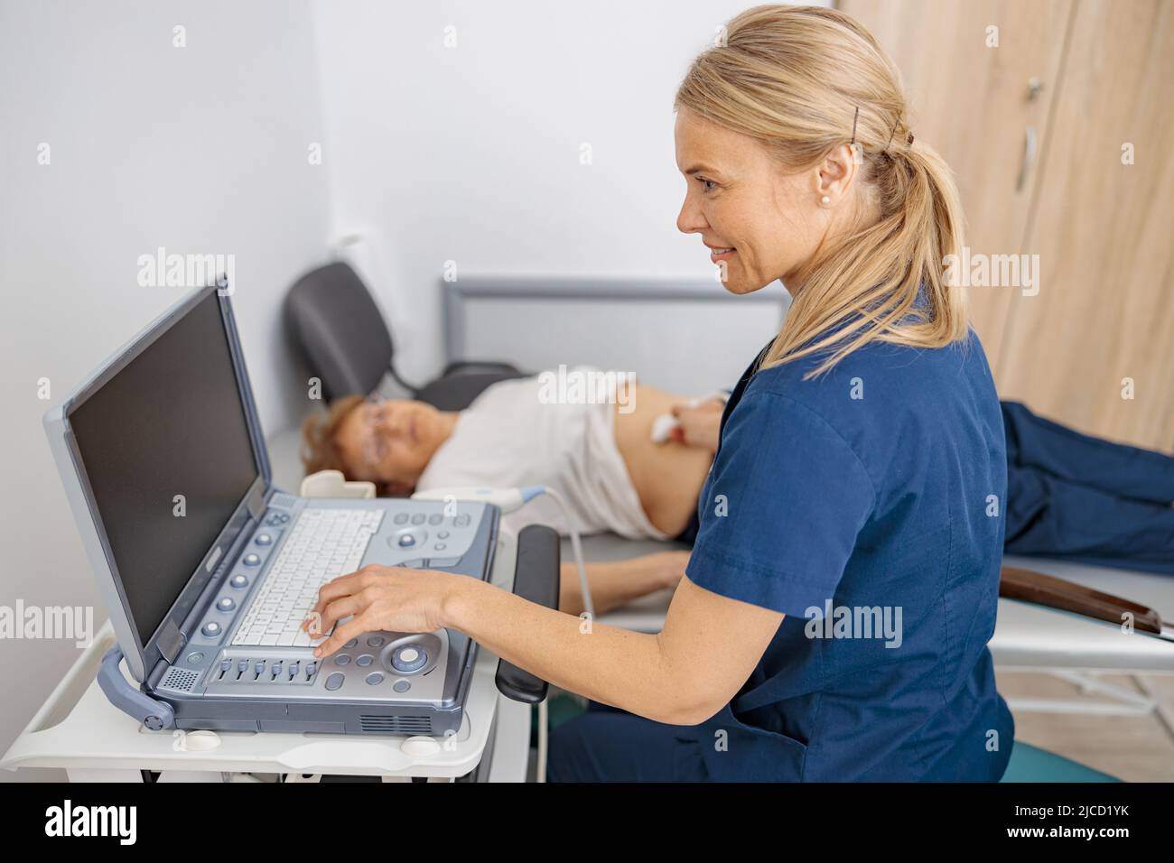 Medico ecografia esaminare l'addome paziente femminile in ospedale. Centro di diagnosi prenatale Foto Stock