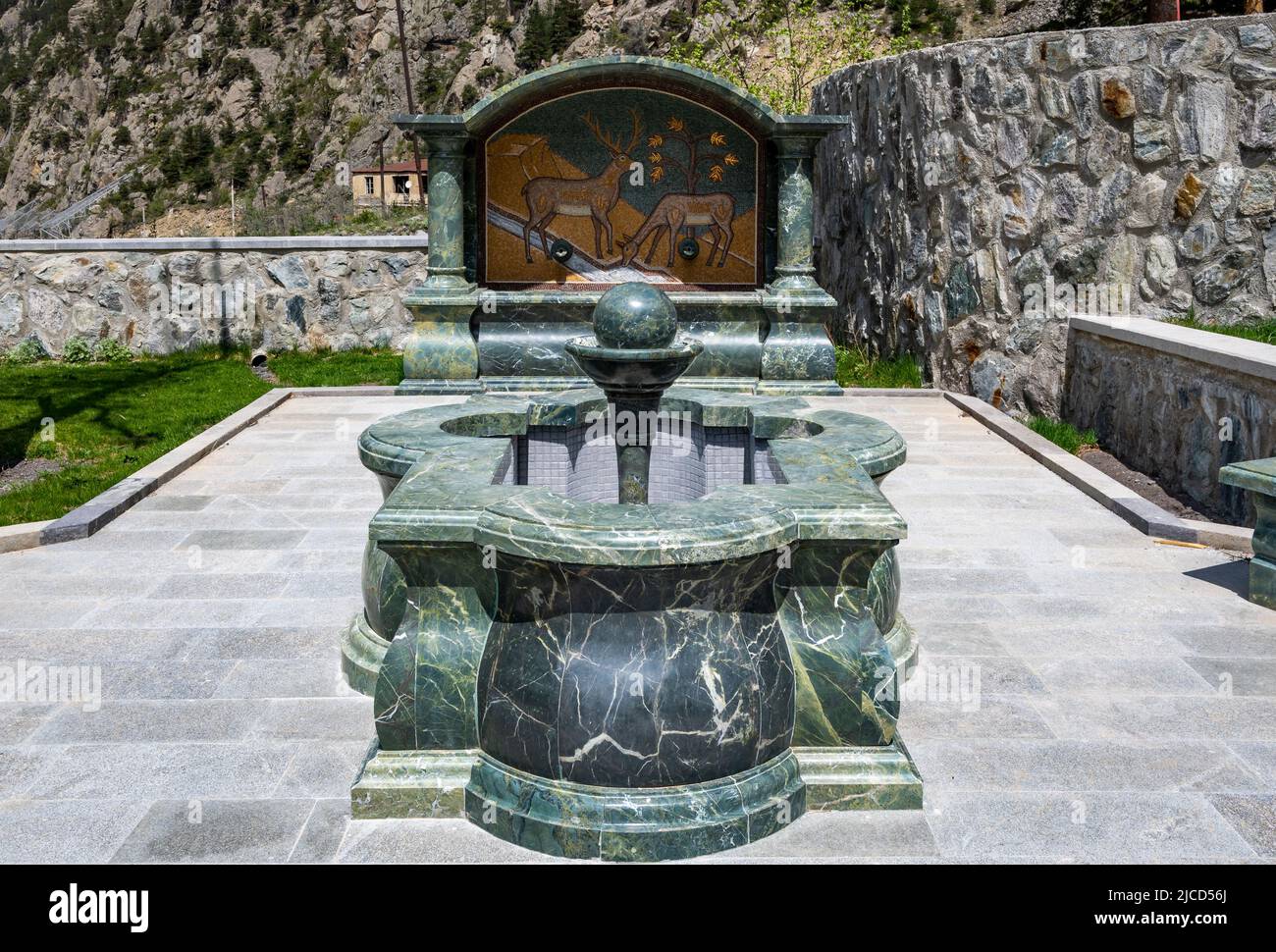 Una fontana d'acqua scolpita da verde serpentina di pietra. Il Monastero di Dariali. Montagne del Caucaso. Kazbegi, la Repubblica di Georgia. Foto Stock