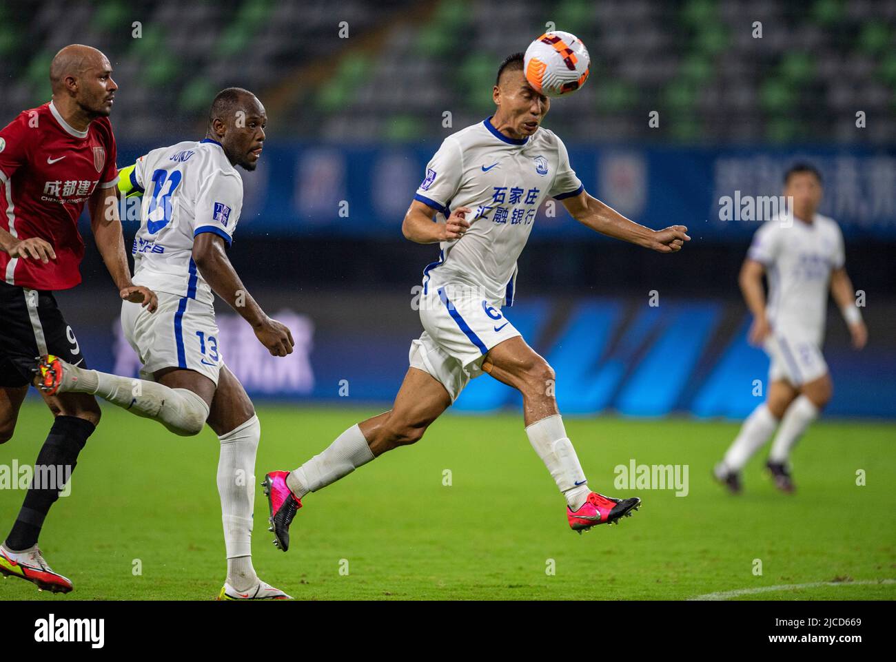 Meizhou, la provincia cinese di Guangdong. 12th giugno 2022. Yang Yun (R) di Cangzhou Mighty Lions si dirige per la palla durante una partita della Superlega dell'Associazione Cinese del Calcio (CSL) della stagione 2022 tra il Cangzhou Mighty Lions FC e il Chengdu Rongcheng FC a Meizhou, provincia del Guangdong della Cina meridionale, il 12 giugno 2022. Credit: Sun Fei/Xinhua/Alamy Live News Foto Stock