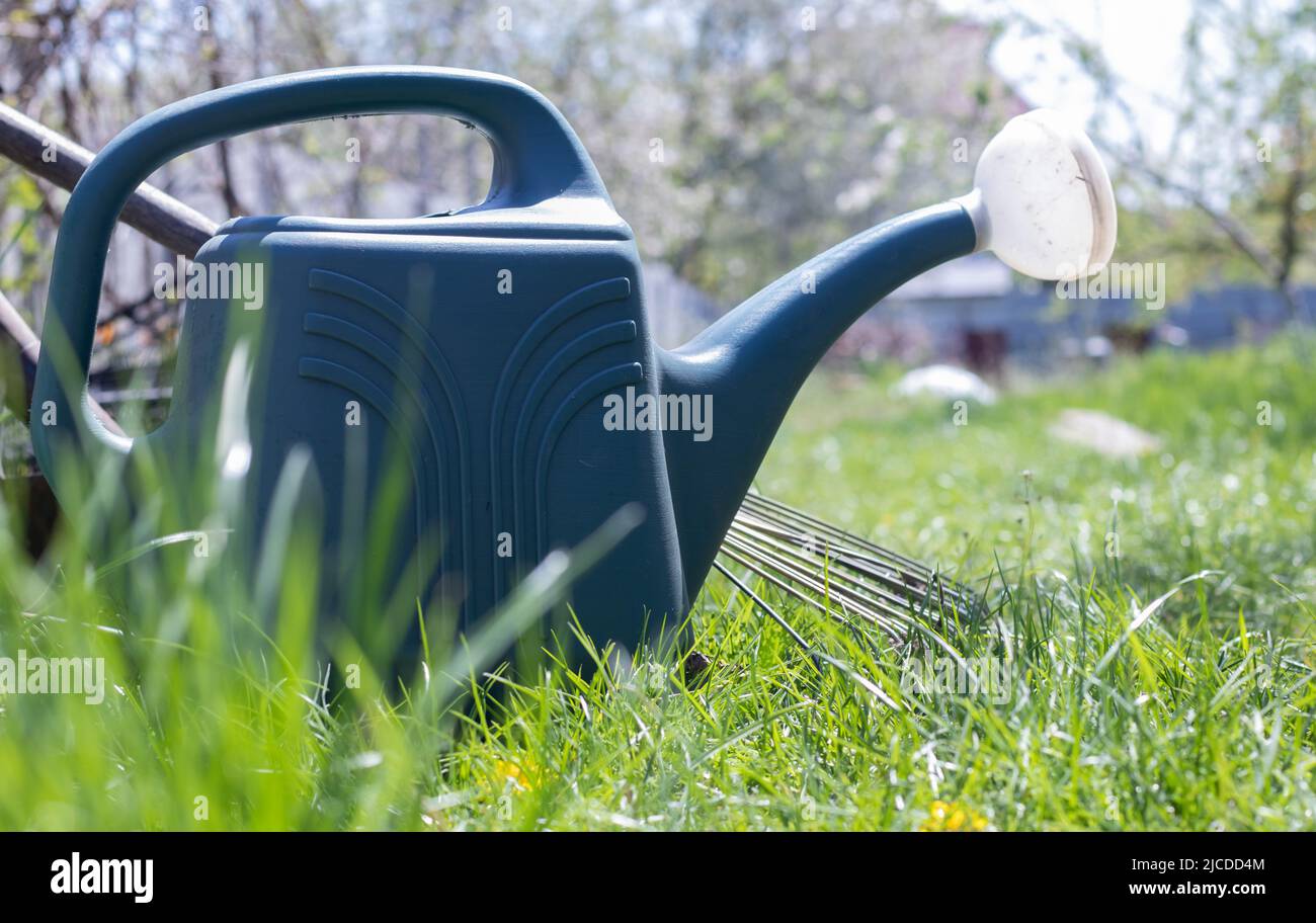 Vaso in plastica blu per innaffiare in giardino. Può annaffiare. Annaffiatoio per fiori in strada, in giardino o in giardino in una calda giornata estiva di sole Foto Stock