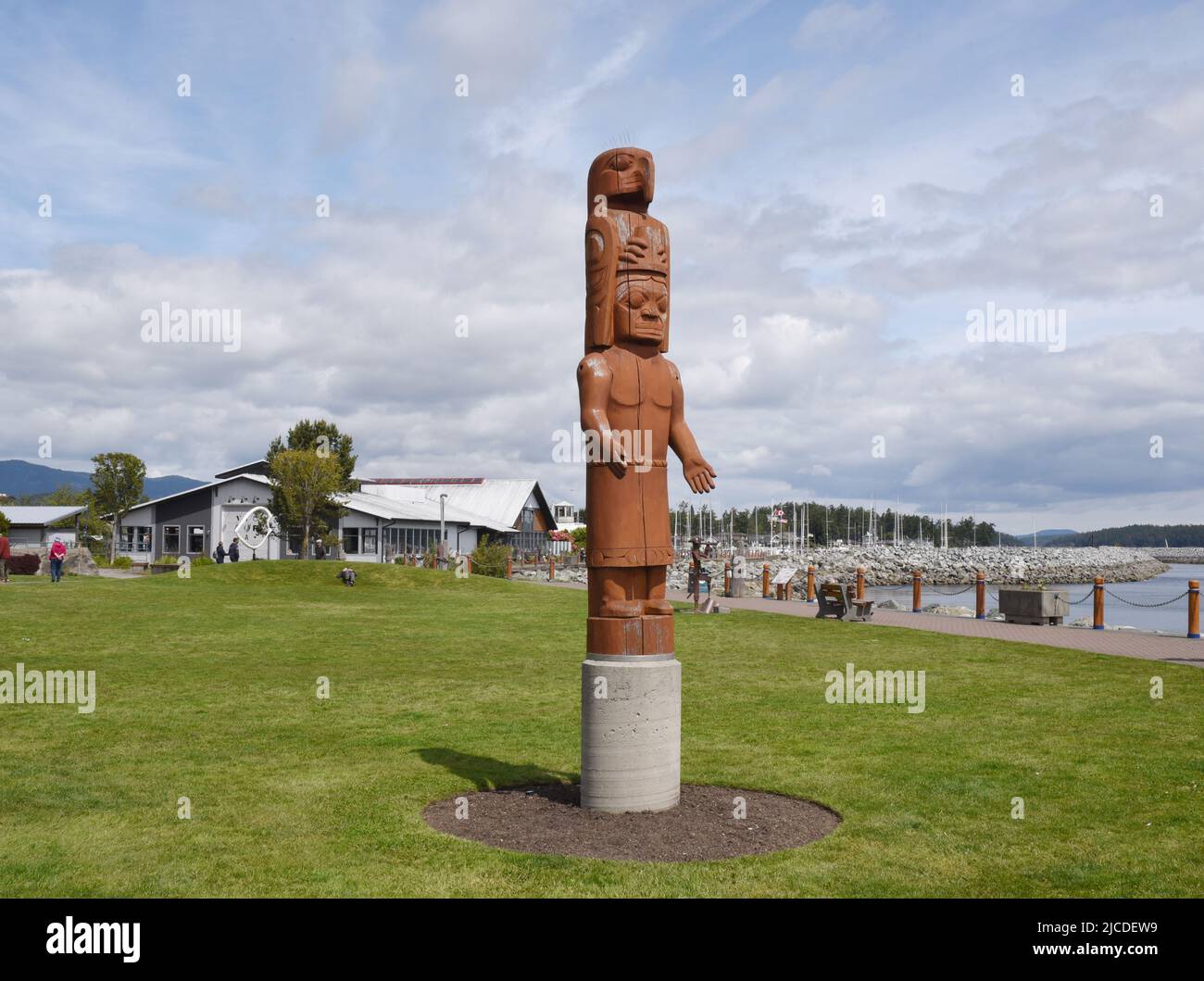 Una vista di un polo indigeno scolpito totem e il porto e il porto turistico a Sidney, British Columbia, sull'isola di Vancouver, Canada. Foto Stock