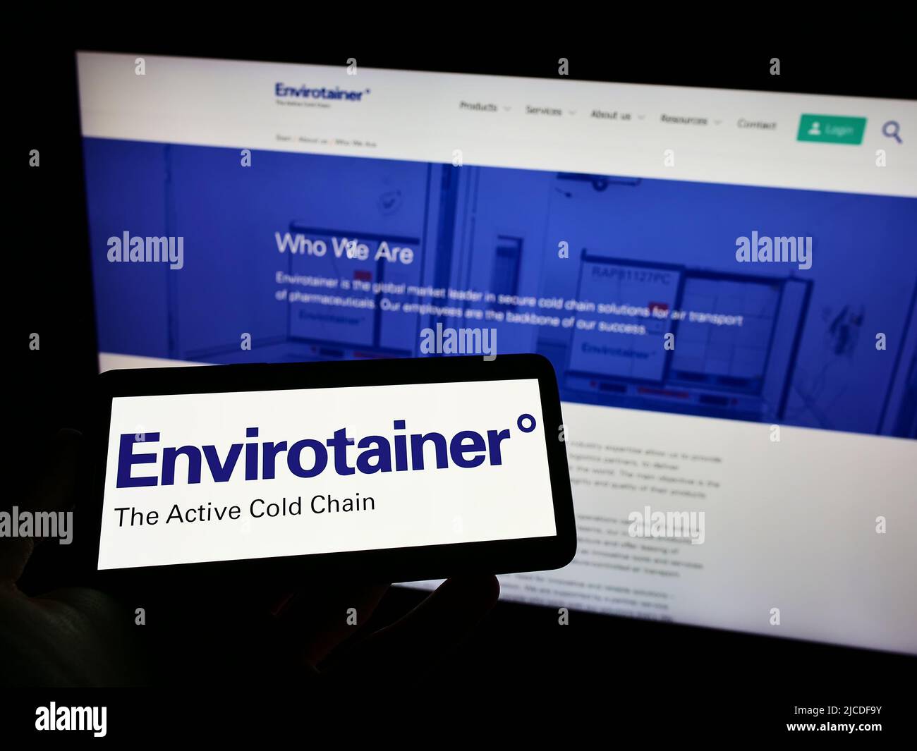 Persona che tiene il telefono cellulare con il logo della società di logistica svedese Envirotainer AB sullo schermo di fronte alla pagina web aziendale. Mettere a fuoco sul display del telefono. Foto Stock