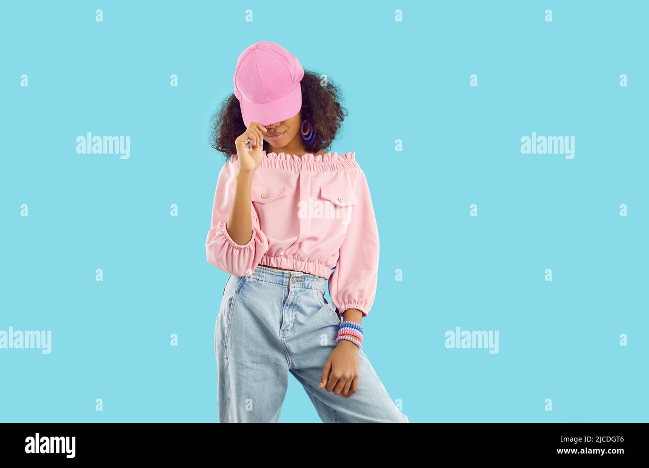 Afro American bambino in abito alla moda e cappellino rosa da baseball in posa in studio di moda Foto Stock