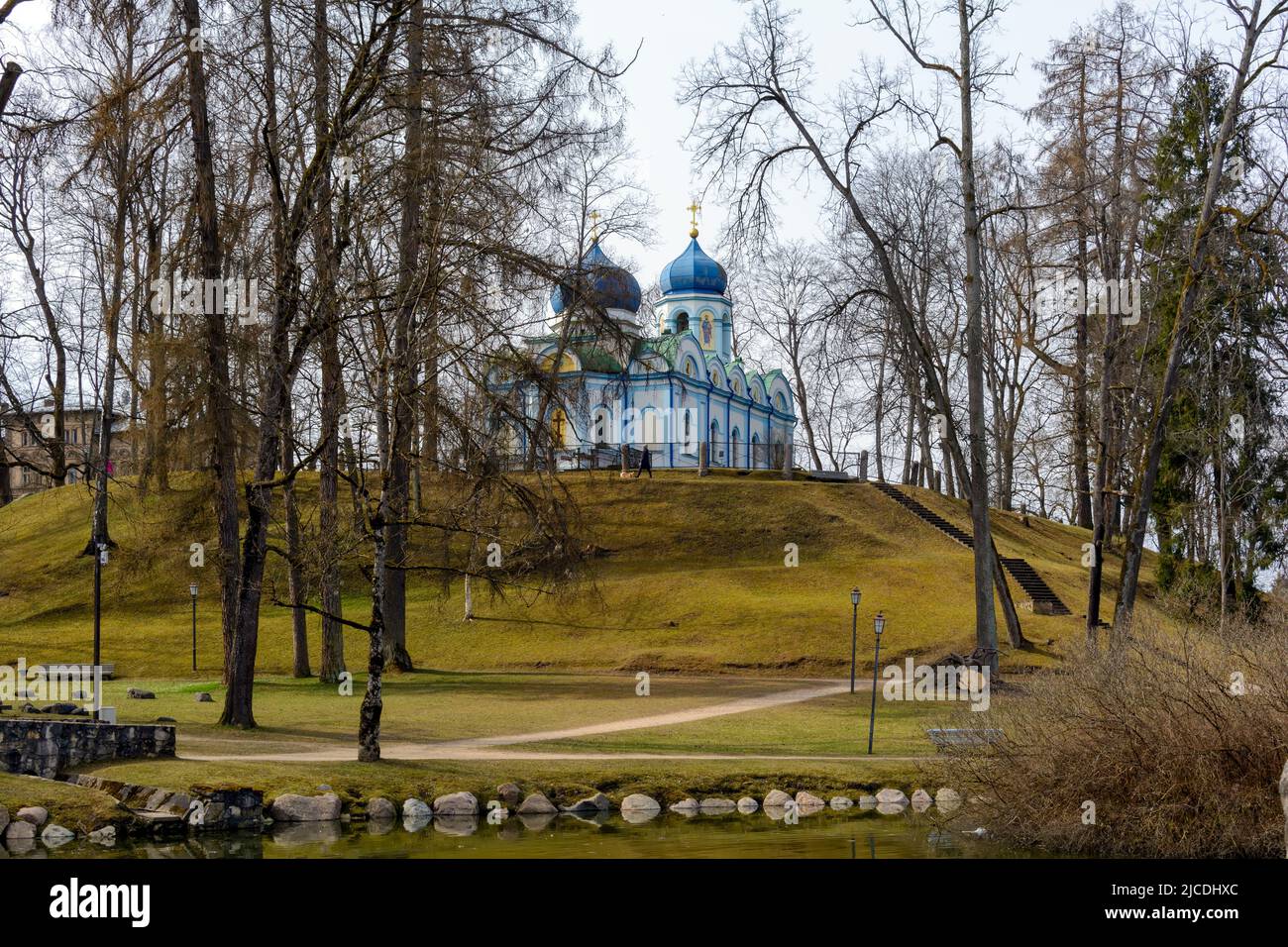 Trasfigurazione bianca in stile bizantino della Chiesa ortodossa di Cristo di Cesis con le sue cupole blu in piedi su un pendio di collina nel Parco del Castello di Cesis. Foto Stock
