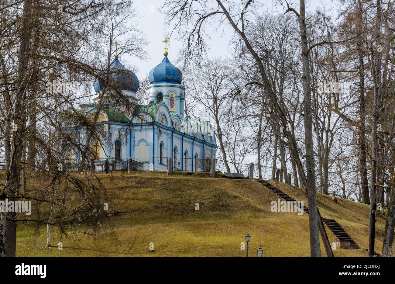 Trasfigurazione bianca in stile bizantino della Chiesa ortodossa di Cristo di Cesis con le sue cupole blu in piedi su un pendio di collina nel Parco del Castello di Cesis. Foto Stock