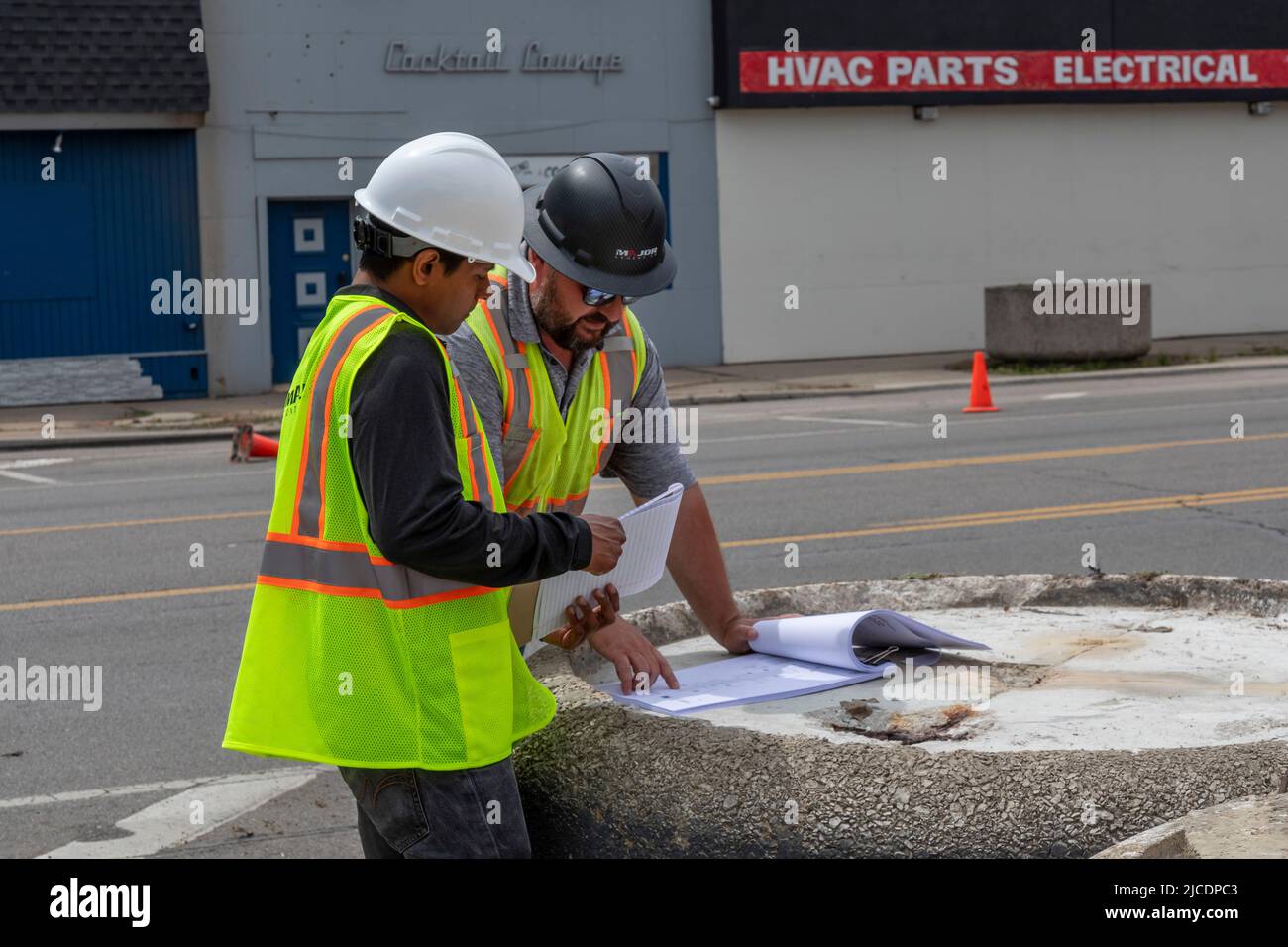 Detroit, Michigan - i lavoratori edili guardano al progetto di miglioramento del paesaggio urbano su East Warren Avenue, dove ci sono molti magazzini vuoti. Th Foto Stock