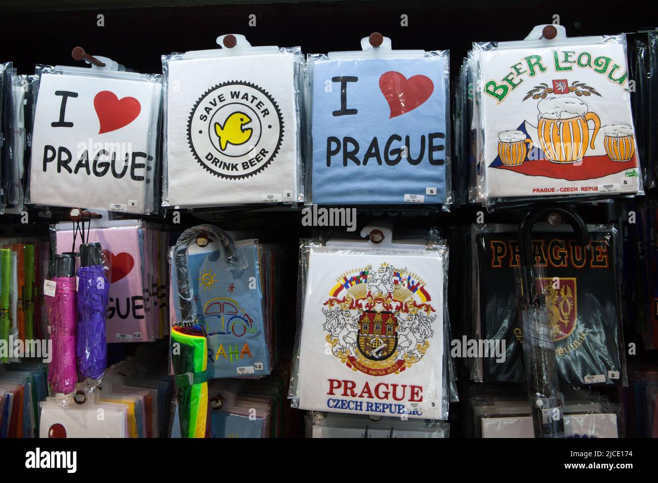 T-shirt e ombrelloni ricordo in vendita in un negozio di souvenir in via Celetná a Staré Město (Città Vecchia) a Praga, Repubblica Ceca. Foto Stock