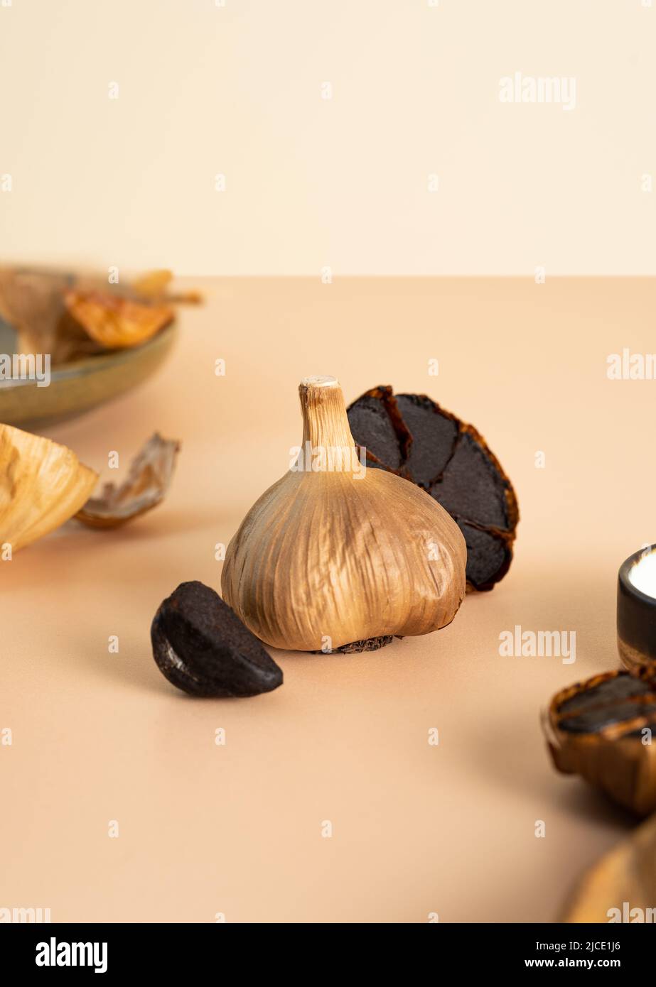 Una composizione concettuale di cibo fermentato. Bulbi d'aglio nero,  spicchi e buccia giacciono su un tavolo beige. Alimentazione sana, cibo  vegetariano, self-care Foto stock - Alamy