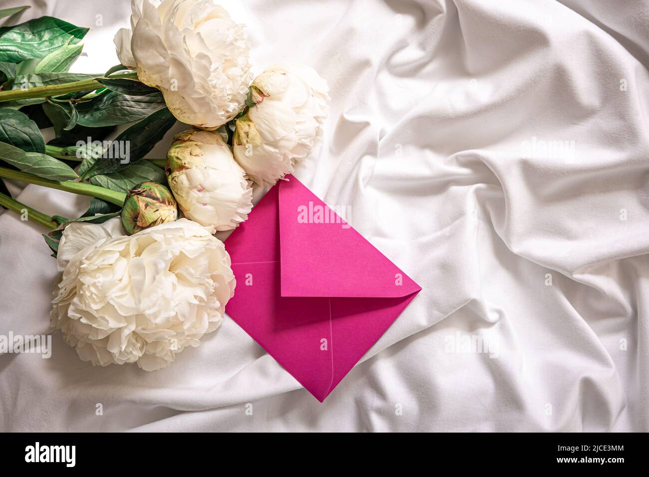 Sfondo con fiori peonie e buste a letto. Foto Stock