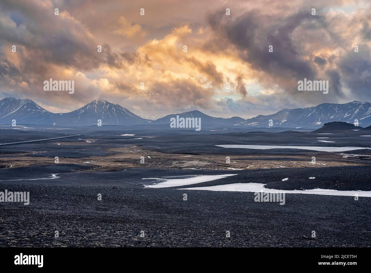 Vista panoramica della neve sul paesaggio vulcanico contro le montagne durante il tramonto Foto Stock