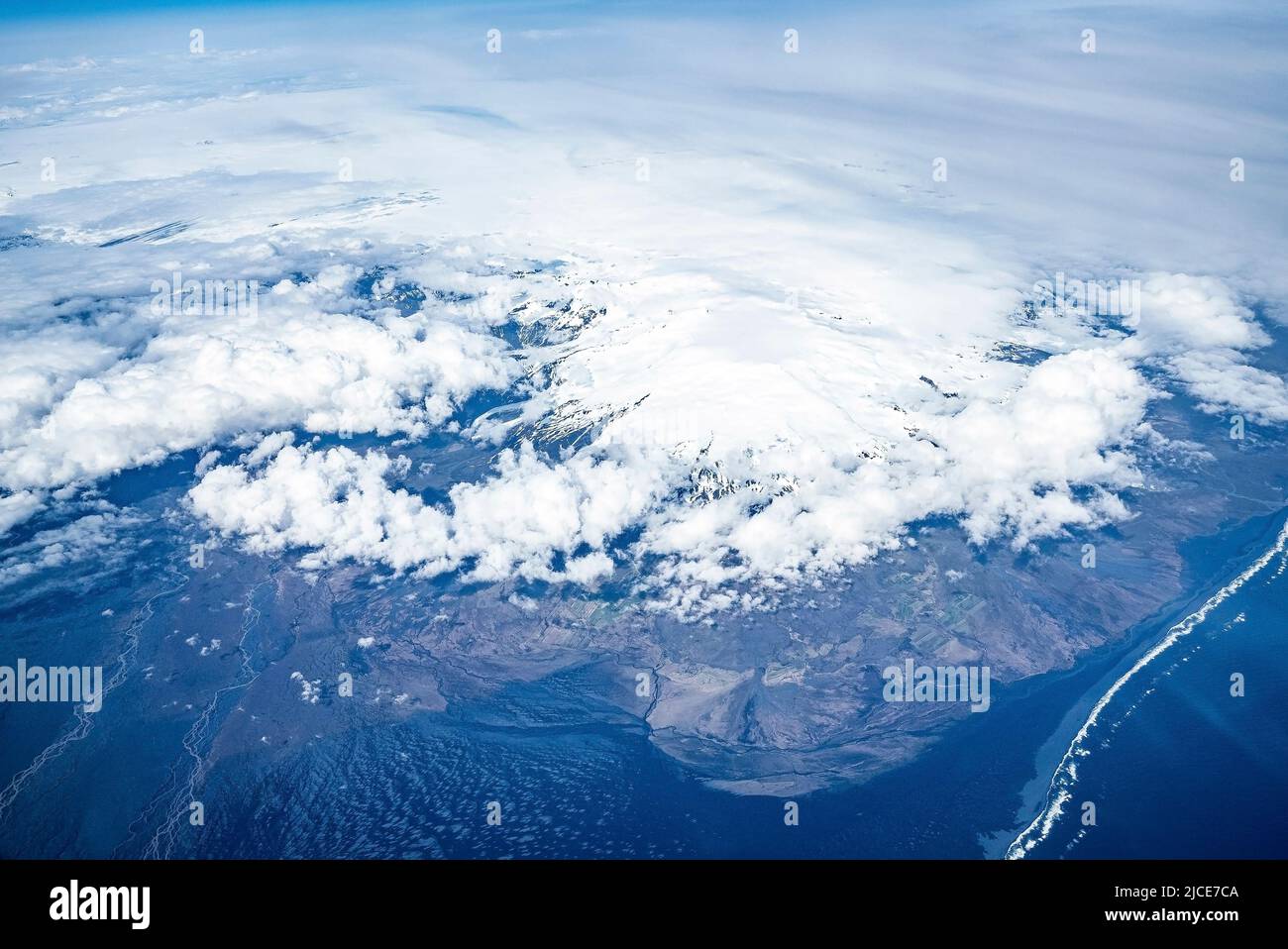 Vista aerea di un bellissimo paesaggio bianco innevato e l'oceano coperto di paesaggio nuvoloso Foto Stock