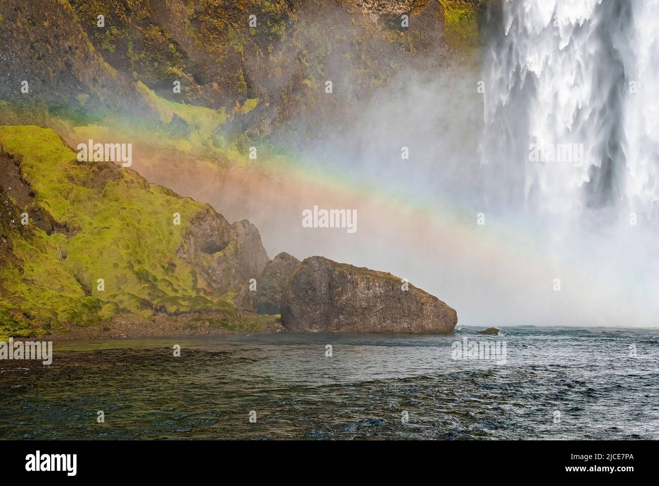 Bellissimo arcobaleno sulle formazioni rocciose e il fiume Skoga contro Skogafoss Foto Stock