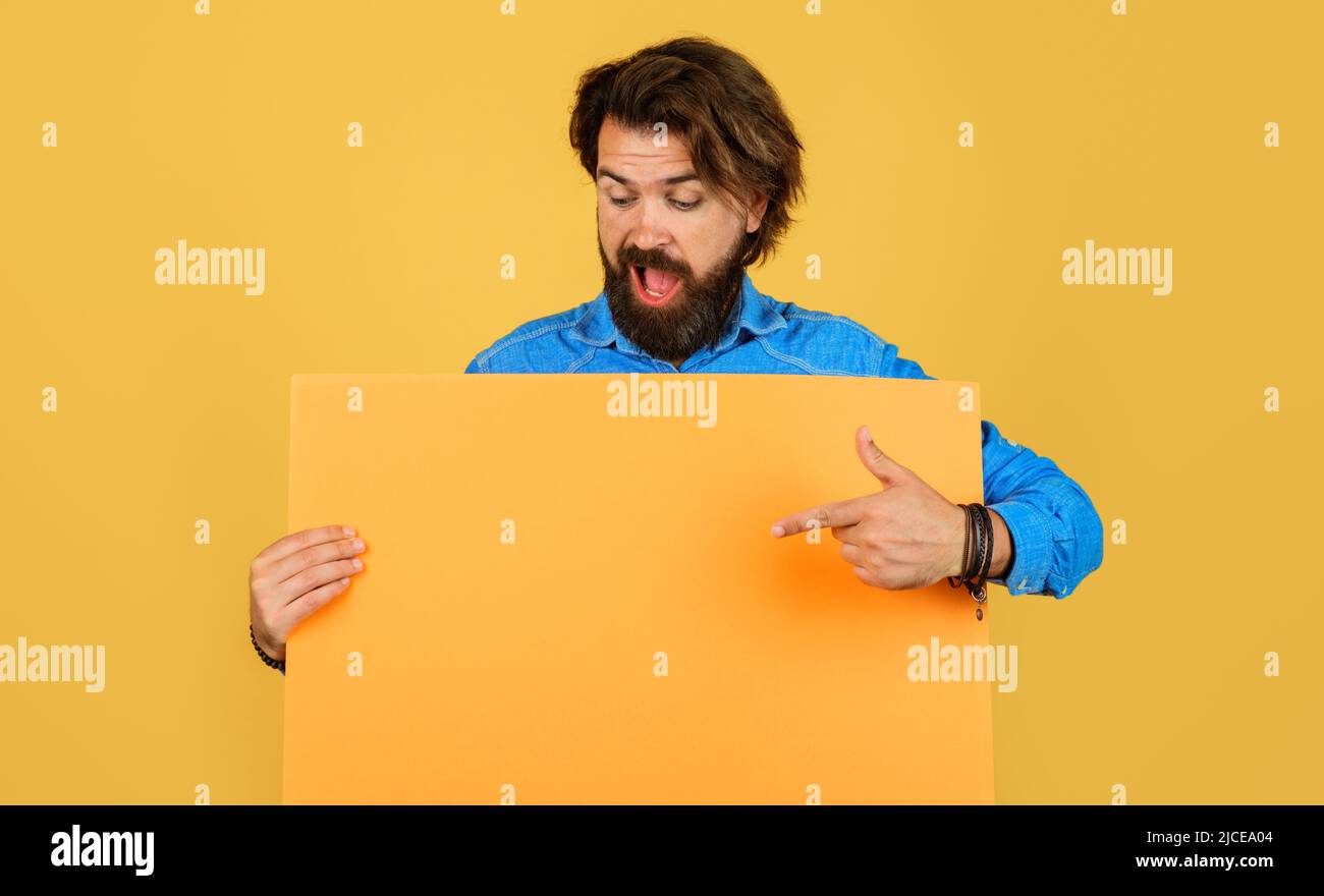 Uomo bearded con bordo di pubblicità che punta il dito allo spazio di copia. Shopping. Vendita stagionale. Sconto Foto Stock Uomo bearded con bordo di pubblicità che punta il dito allo spazio di copia. Shopping. Vendita stagionale. Sconto Foto Stock
