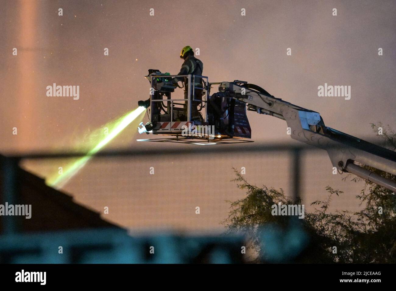 Nechells, Birmingham, Inghilterra, 12 giugno 2022. Oltre 100 vigili del fuoco stanno affrontando un enorme inferno al complesso Smurfit Kappa Recycling di Nechells, Birmingham. Il servizio antincendio delle West Midlands ha implementato 20 apparecchi, tra cui due piattaforme idrauliche aeree, più motori antincendio e un'unità di pompaggio dell'acqua ad alto volume. L'incidente coinvolge 8000 tonnellate di balle di carta e cartone in fiamme in un magazzino. Credito: Interrompi stampa Media/Alamy Live News Foto Stock