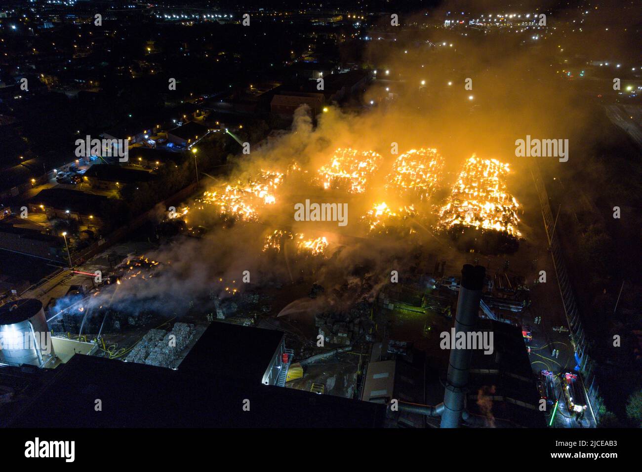 Nechells, Birmingham, Inghilterra, 12 giugno 2022. Oltre 100 vigili del fuoco stanno affrontando un enorme inferno al complesso Smurfit Kappa Recycling di Nechells, Birmingham. Il servizio antincendio delle West Midlands ha implementato 20 apparecchi, tra cui due piattaforme idrauliche aeree, più motori antincendio e un'unità di pompaggio dell'acqua ad alto volume. L'incidente coinvolge 8000 tonnellate di balle di carta e cartone in fiamme in un magazzino. Credito: Interrompi stampa Media/Alamy Live News Foto Stock