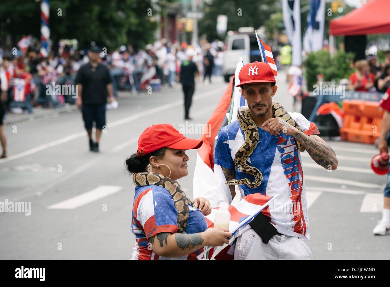 Due partecipanti al Bushwick Puerto Rico Day Parade con i loro serpenti animali domestici. Foto Stock