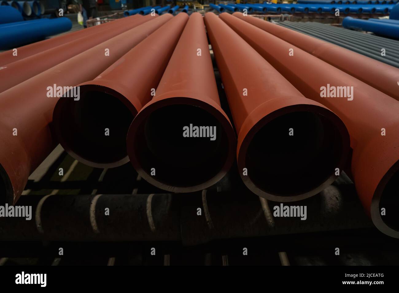 Gruppo di tubi metallici per acqua o acque reflue in primo piano nei magazzini di fabbriche metallurgiche. Foto Stock