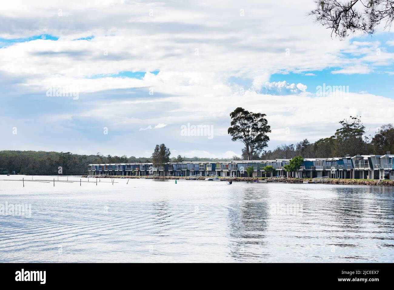 Cabine per le vacanze costruite lungo il bordo del lago Conjola (Garrad Way) sul nuovo Galles del Sud, Costa Sud dell'Australia Foto Stock