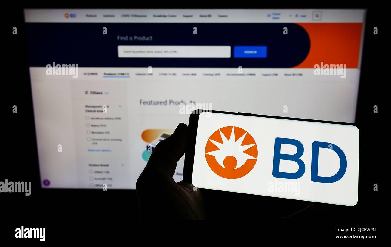 Persona che tiene uno smartphone con il logo della società medica statunitense Becton, Dickinson and Co (BD) sullo schermo di fronte al sito Web. Mettere a fuoco sul display del telefono. Foto Stock