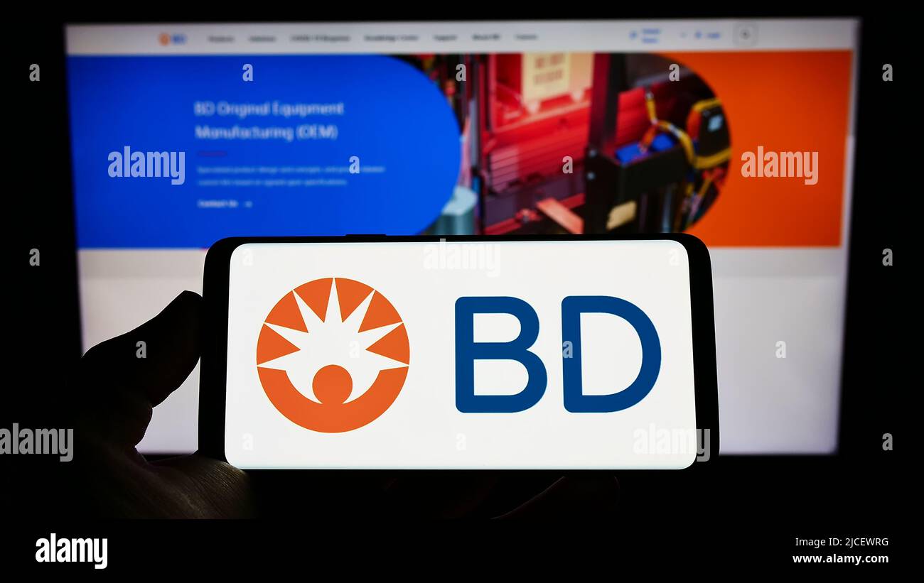 Persona che tiene il cellulare con il logo della società medica americana Becton, Dickinson e Co (BD) sullo schermo di fronte alla pagina web. Mettere a fuoco sul display del telefono. Foto Stock